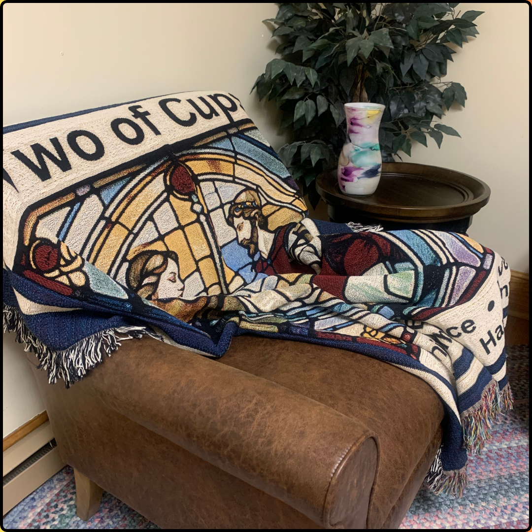 Two of Cups Heirloom Blanket Mister Obtuse mugs and stuff draped over brown leather chair